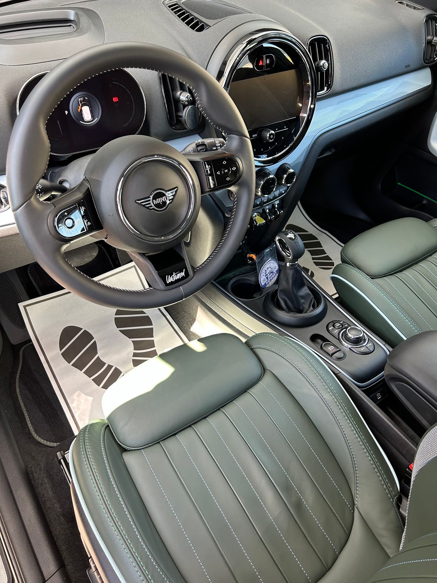 Interior view of a car showcasing the steering wheel, dashboard, and front leather seats.