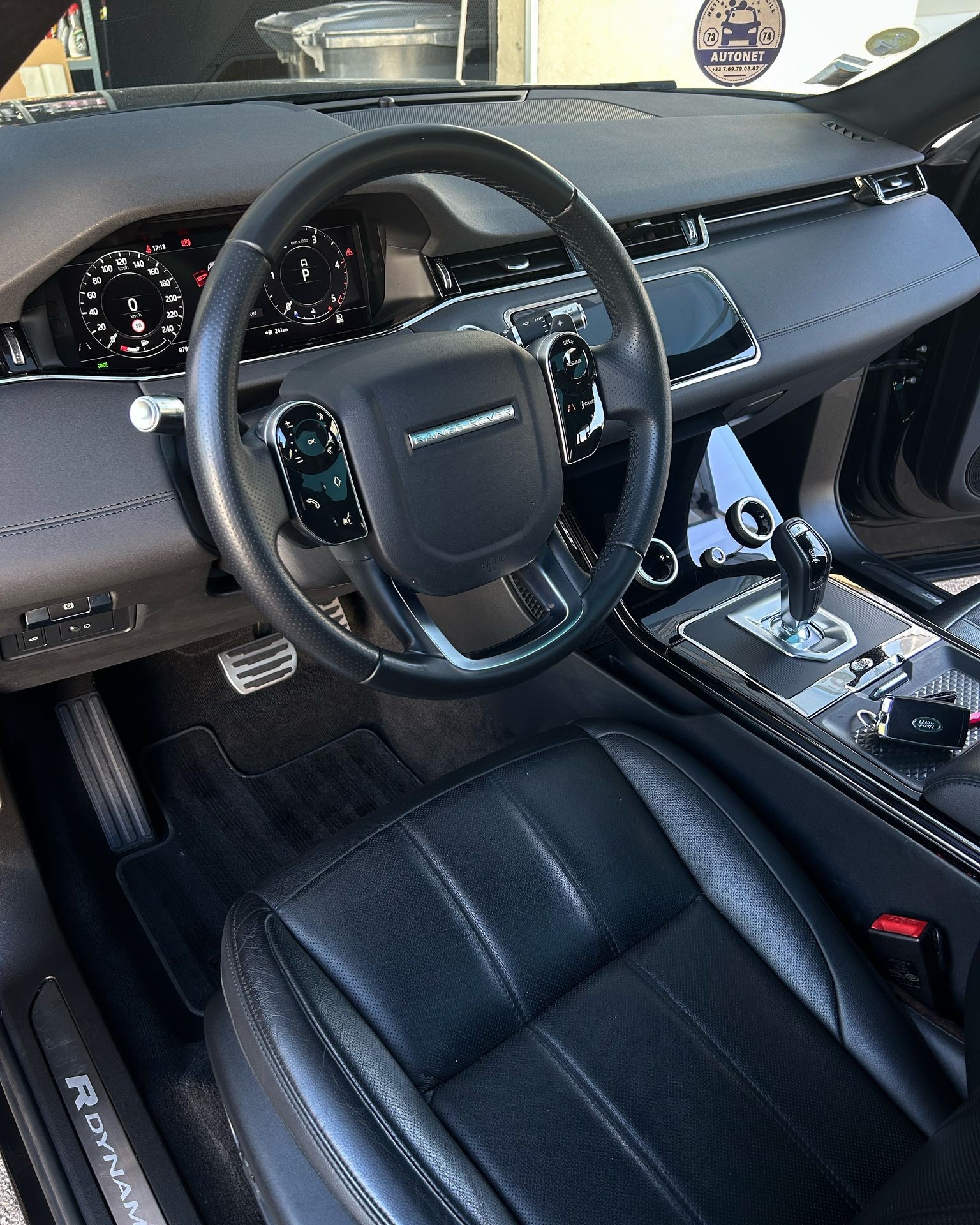 Interior view of a luxury car showing the steering wheel, dashboard, and leather seat.